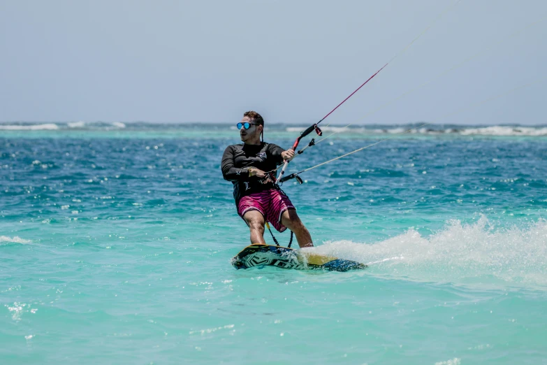 a man riding a board on top of a body of water, a picture, pexels contest winner, hurufiyya, aruba, kites, avatar image