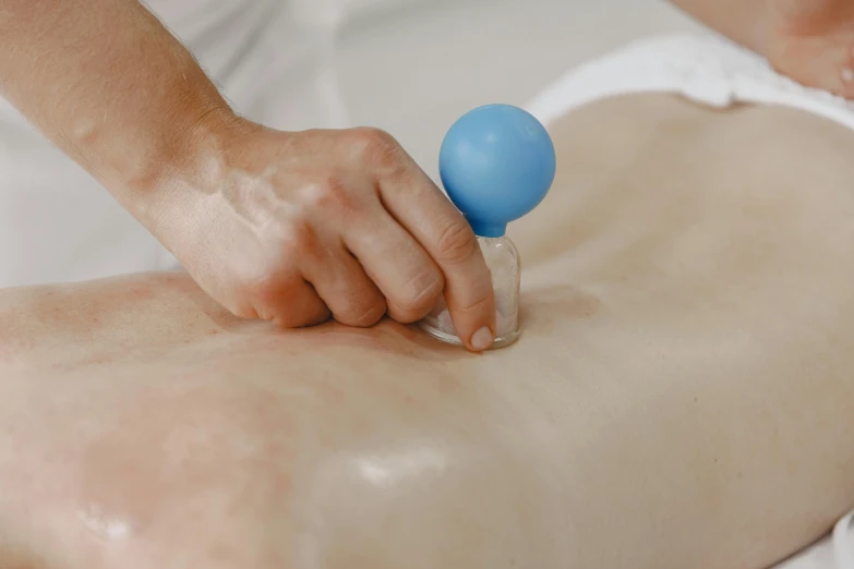 a close up of a person getting a massage, glass ball at the waist, blue paint on top, white limbo, anaesthetic