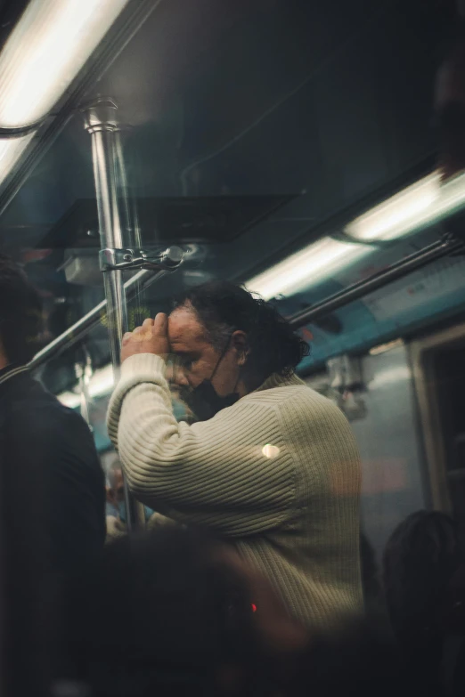 a man on a subway with his head in his hands, inspired by Nan Goldin, pexels contest winner, happening, shot on superia 400 filmstock, ignant, praying, fall season