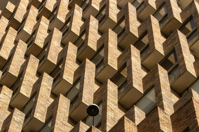 a clock mounted to the side of a brick building, inspired by Ricardo Bofill, unsplash, brutalism, zig zag, brown, 3 4 5 3 1, panels