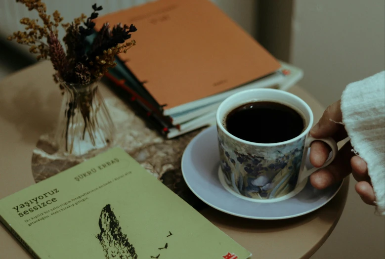 a book, coffee cup and a stack of books