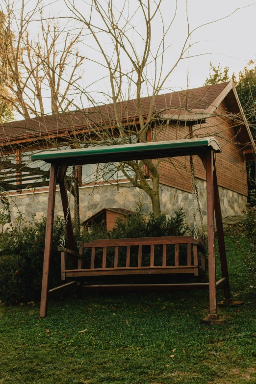 a big swing on the green grass next to a building