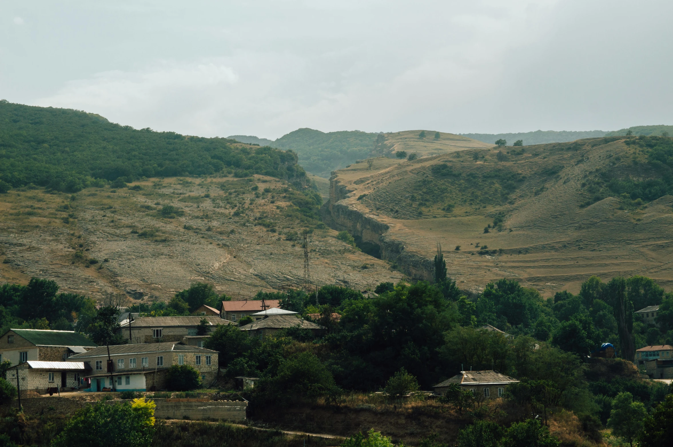 several small village nestled in the mountains under cloudy skies