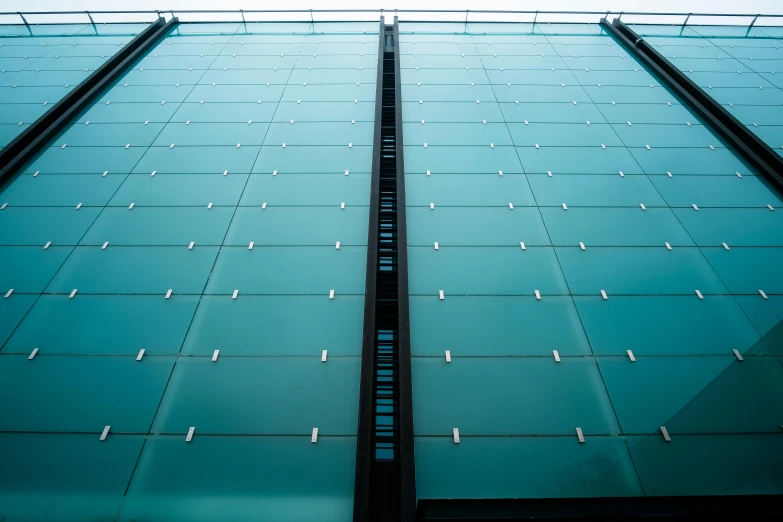 a tall glass building with a sky in the background, inspired by Tadao Ando, unsplash, cyan shutters on windows, square lines, detailed and intricate image, rows of windows lit internally