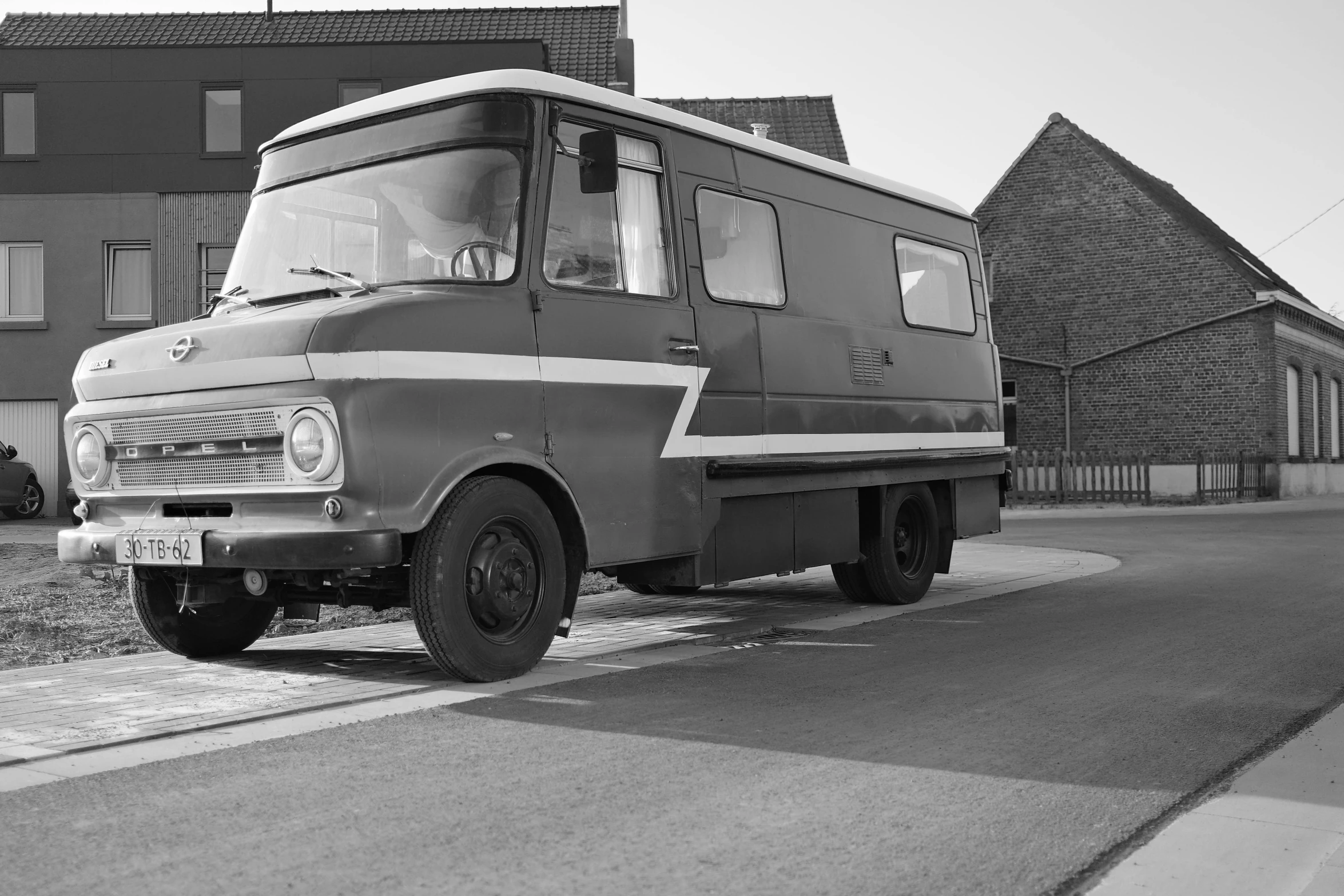 a black and white photo of a van parked on the side of the road, by Jan Tengnagel, restored, bulky build, mcdonald, vhsrip