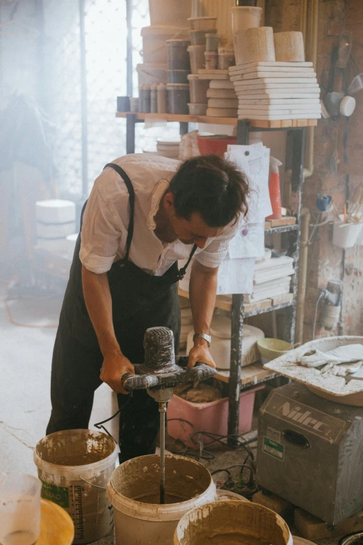 a man is working in a pottery shop, a marble sculpture, inspired by Miyagawa Chōshun, trending on unsplash, female blacksmith, ai weiwei and gregory crewdson, plating, julian ope