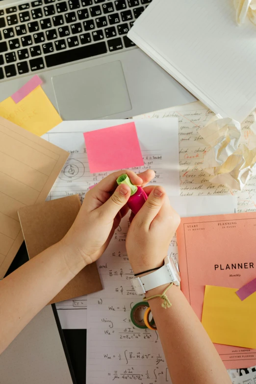 a person sitting at a desk in front of a laptop, by Julia Pishtar, trending on pexels, process art, poster paper with notes, bright construction materials, paper decoration, flatlay