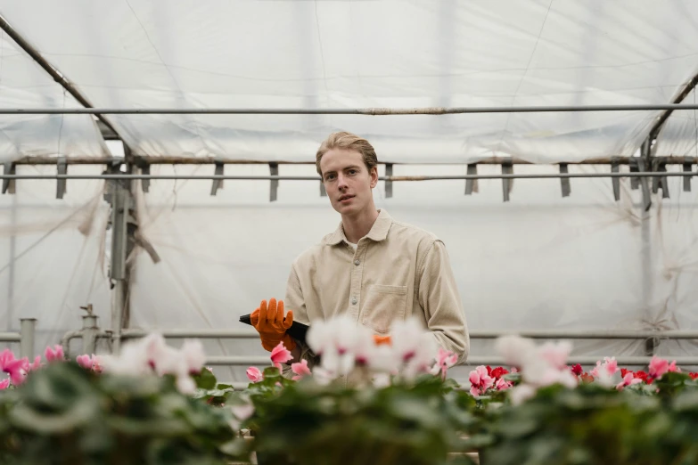 a man holding a potted plant in a greenhouse, a portrait, unsplash, renaissance, flower sepals forming helmet, lachlan bailey, carrying a tray, bartlomiej gawel