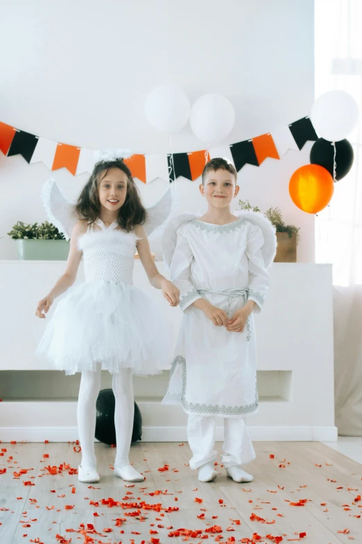 a couple of little girls standing next to each other, pexels, happening, beistle halloween decor, an angel, white and black, at a birthday party