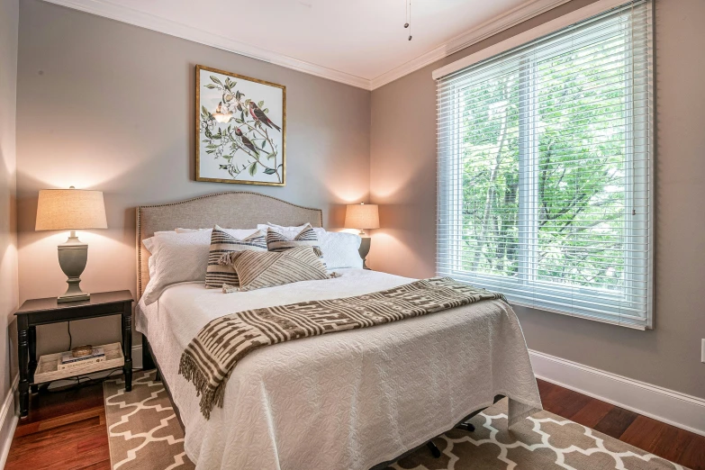 a large bed sitting under a window next to lamps