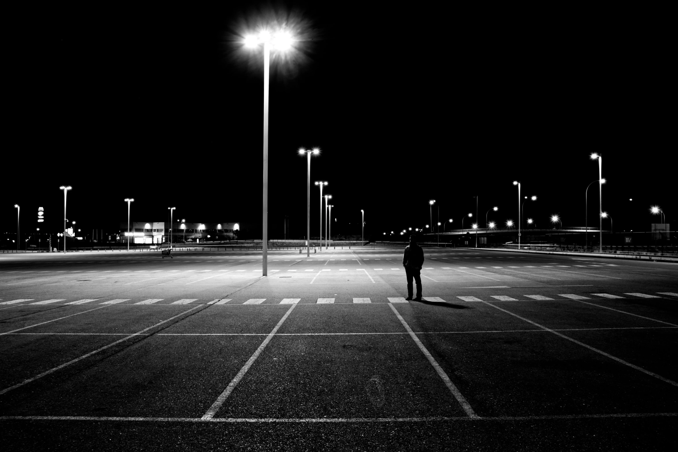 a person standing in a parking lot at night, a black and white photo, pexels contest winner, postminimalism, square, artwork empty daylight, multiple stories, sad man