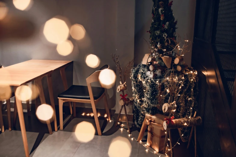 a living area with a christmas tree, chairs, and small lights