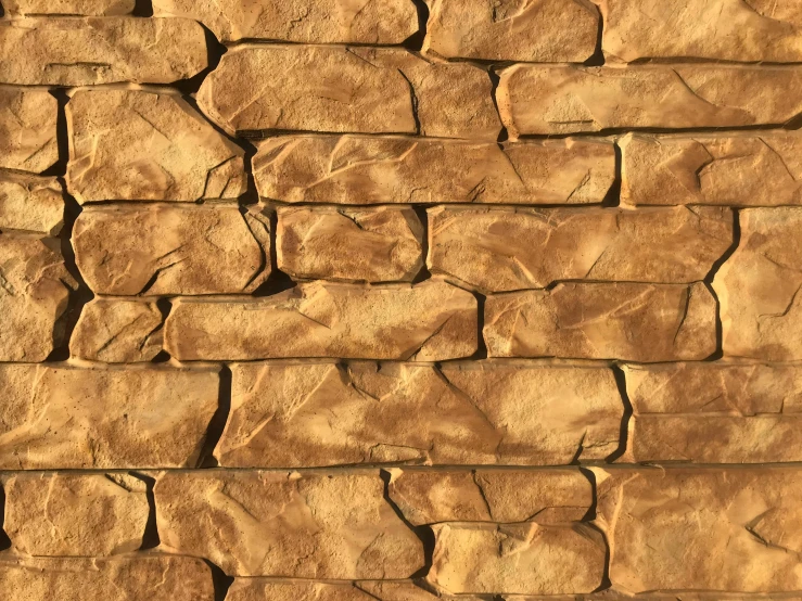 the wall is made out of brown colored rock blocks