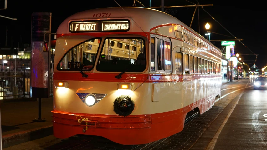 a red and white trolley on a city street at night, orange line, preserved historical, 🚿🗝📝, profile image