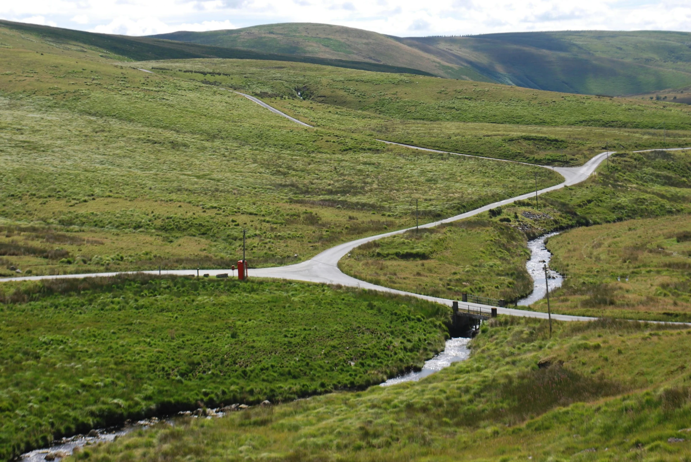 a winding road passes an intersection on the outskirts