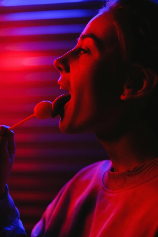 a man with a toothbrush in his mouth, poster art, inspired by Nan Goldin, pexels, red light bulbs, eating mars bar candy, red room, dessert