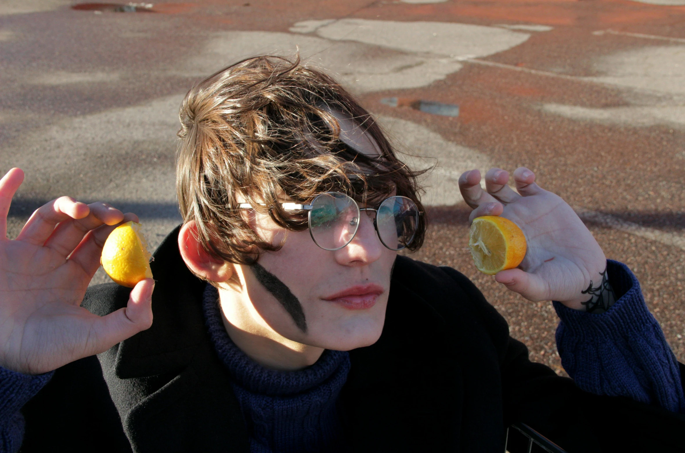 a young man holding two lemons in front of his face, an album cover, unsplash, cosplay, non binary model, 🐿🍸🍋, in the sun