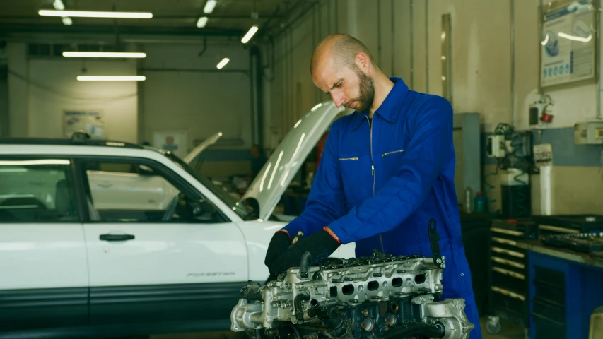 a man working on a car engine in a garage, a portrait, inspired by Harry Haenigsen, shutterstock, renaissance, 15081959 21121991 01012000 4k, demna gvasalia, subtitles, blue print