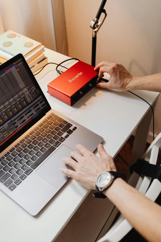 a woman sitting at a desk using a laptop computer, an album cover, inspired by John McLaughlin, trending on unsplash, synthetism, red theme, oscilloscope, thumbnail, professional product shot