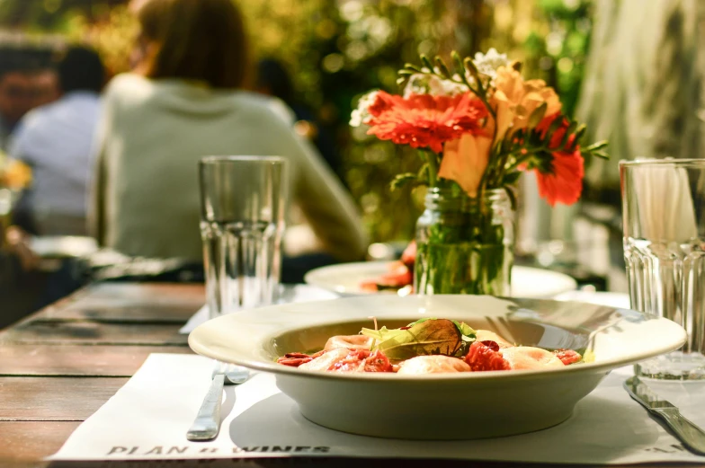 the flowers are in a vase sitting on a plate