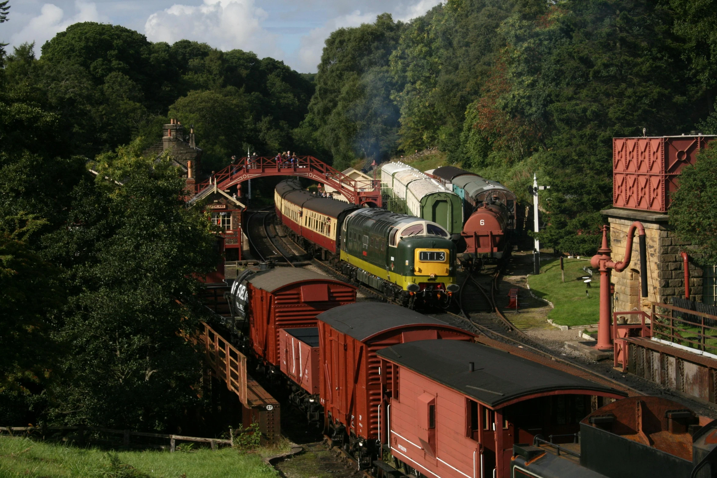 a train traveling down train tracks next to a forest, english heritage, avatar image, slide show, a high angle shot