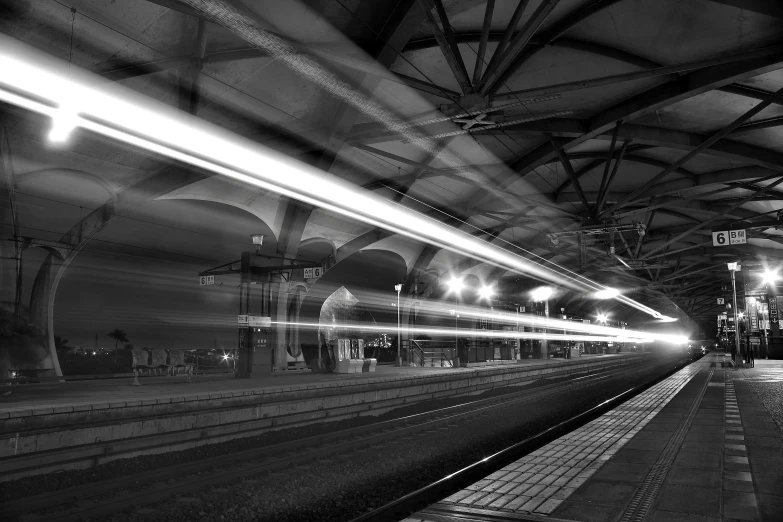 a black and white photo of a train station, a picture, by Kristian Zahrtmann, pexels, time - lapse, under light, composite, 1