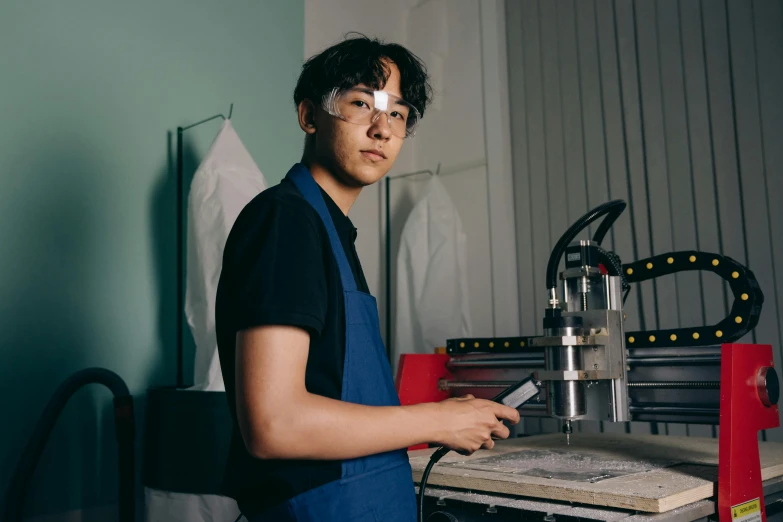 a man standing in front of a machine, a silk screen, pexels contest winner, jaeyeon nam, profile photo, teenage engineering moad, in a workshop