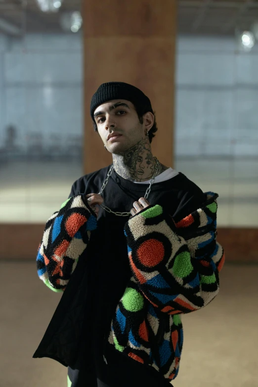 a young man is posing while wearing a jacket