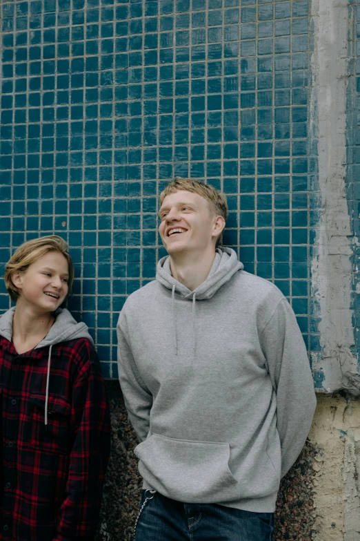 a man and a woman standing next to each other, an album cover, by Jaakko Mattila, unsplash, smiling laughing, wearing a blue hoodie, a blond, two young men