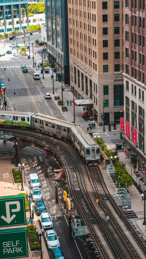 a city street filled with lots of traffic next to tall buildings, by Chris Rahn, pexels contest winner, train station in summer, chicago, underground metro, high angle view