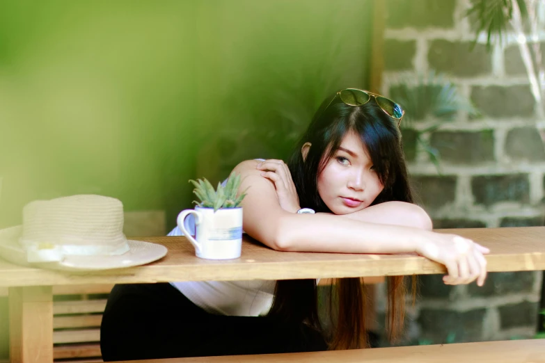 a woman sitting at a table with a hat on her head, inspired by Tan Ting-pho, unsplash, soft green natural light, anime thai girl, avatar image, relaxed pose