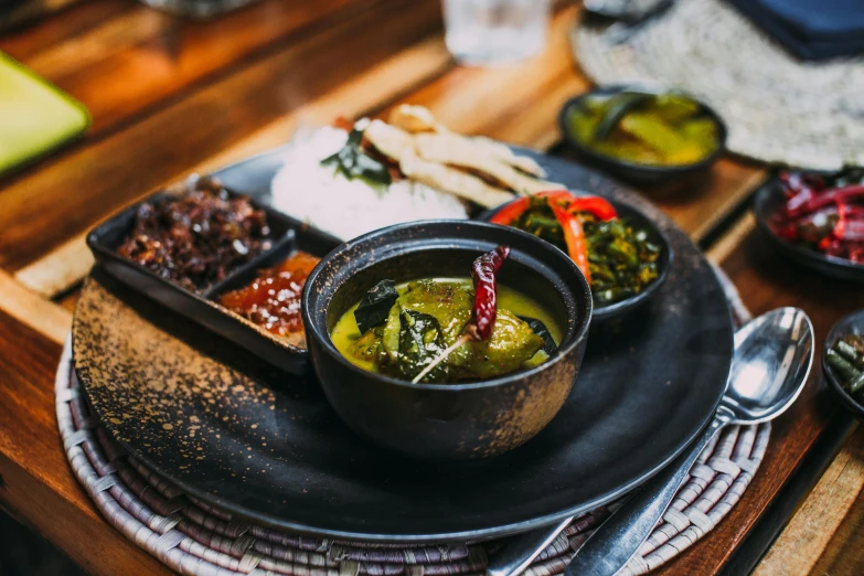 a close up of a plate of food on a table, hurufiyya, bali, olive green, soup, pan and plates