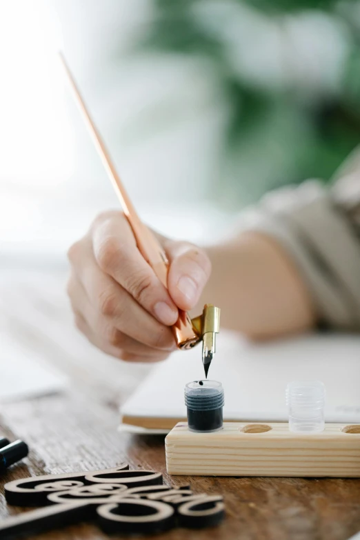 a person holding a pen that is near some paint