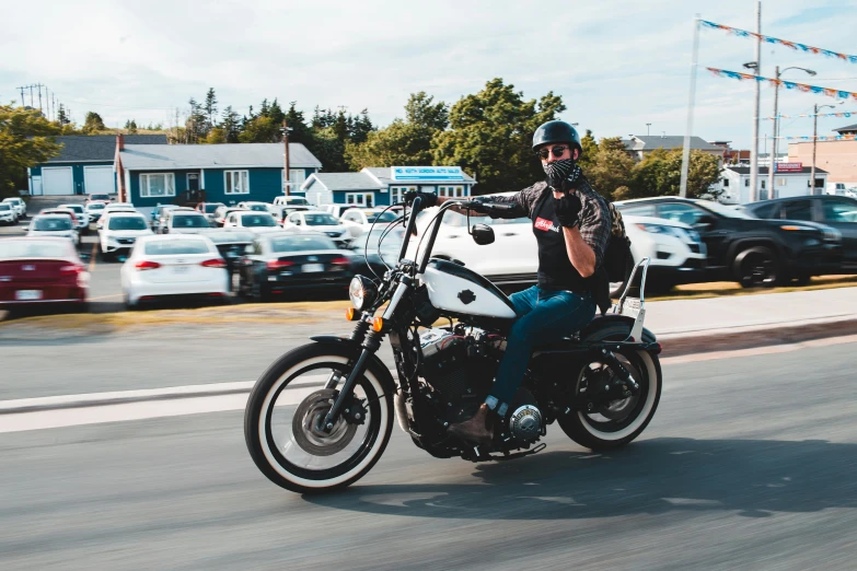 a man riding on the back of a motorcycle down a street, pexels contest winner, te pae, gimli, harley queen, student