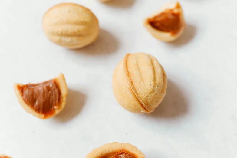 a bunch of nuts sitting on top of a table, on a white table, pochi iida, baking cookies, coated pleats