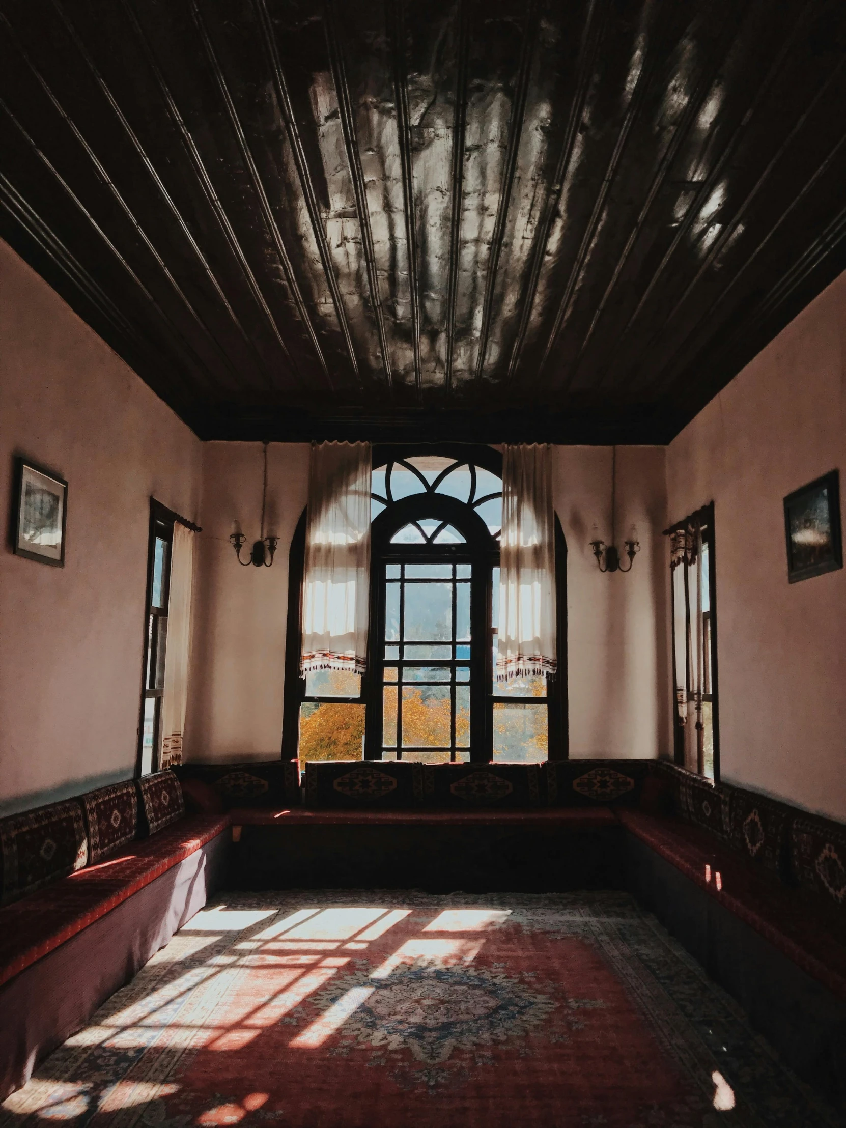 a beautiful room is shown with a window and red carpet