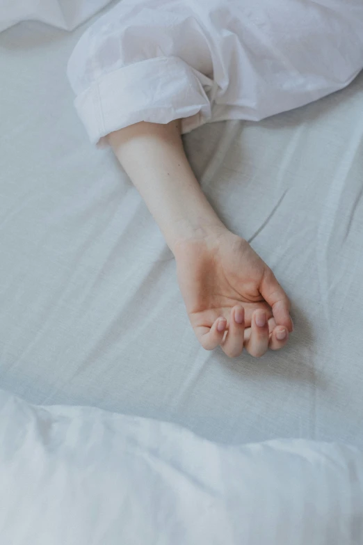 a close up of a person laying on a bed, trending on pexels, close-up of thin soft hand, plain background, ilustration, writhing