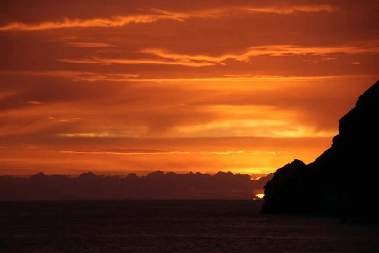 a large body of water with a sunset in the background, pexels contest winner, romanticism, abel tasman, skull island, orange glow, silhouette