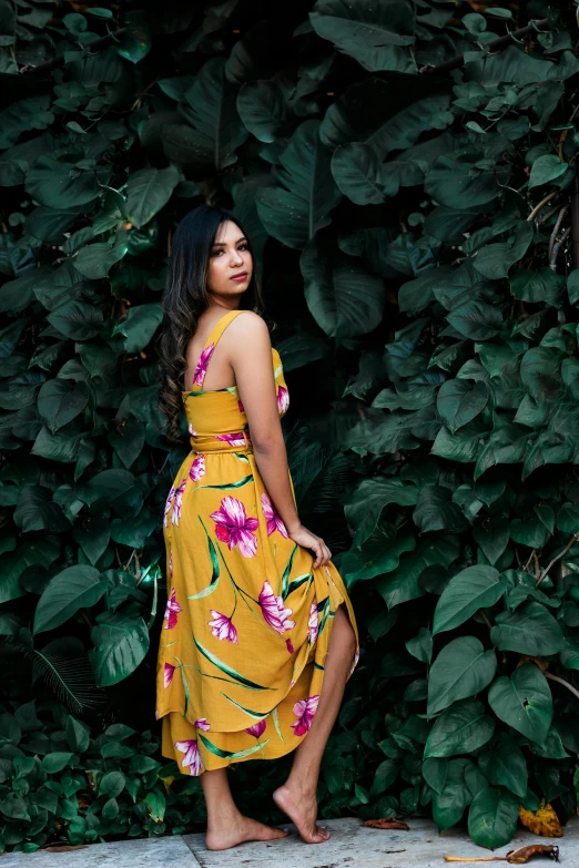 a woman in a yellow dress standing in front of a bush, a picture, by Robbie Trevino, unsplash, wearing a hawaiian dress, young asian woman, 💋 💄 👠 👗, dark backdrop