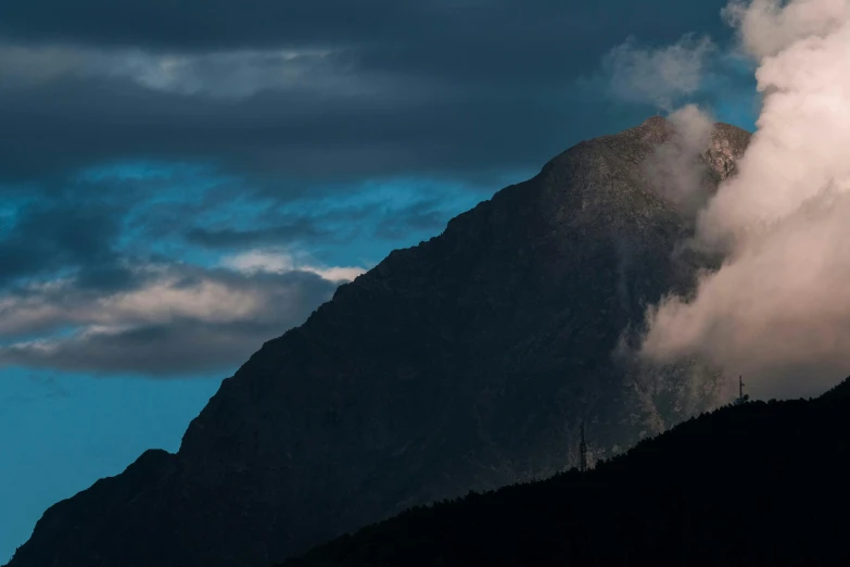 clouds are forming a mountain peak at dusk