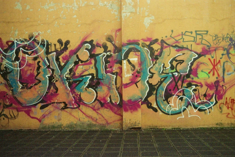 a red fire hydrant sitting in front of a wall covered in graffiti, flickr, graffiti, 2 0 0 0's photo, faded colours, pink concrete, kano)