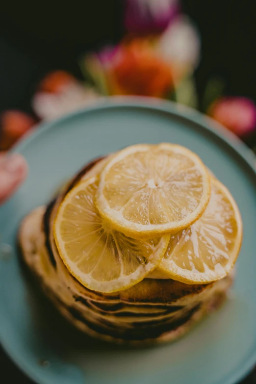 a stack of pancakes sitting on top of a blue plate, trending on unsplash, romanticism, wearing a lemon, detail shot, botanicals, close up of face