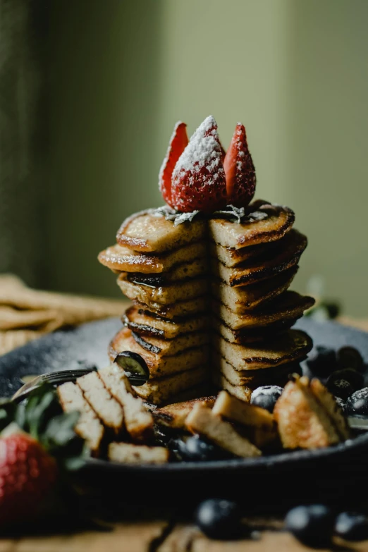 a plate full of pancakes and berries on the table