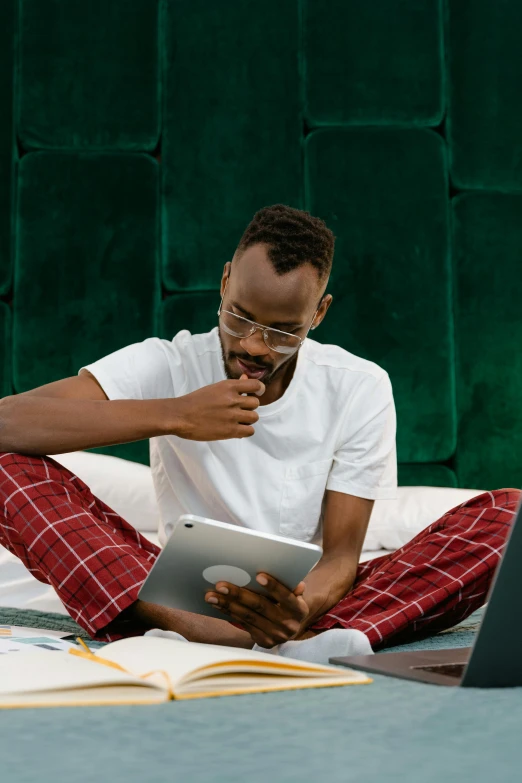 a man sitting on a bed using a laptop, inspired by Barthélemy Menn, trending on pexels, happening, adut akech, wearing a baggy pajamas, nerds, smoking with squat down pose