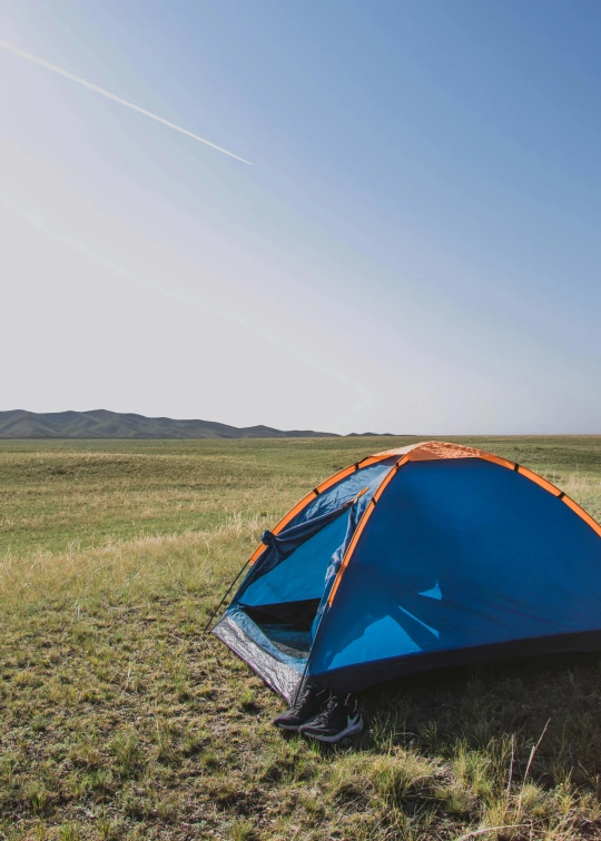 a blue and orange tent sitting on top of a grass covered field, in the steppe, profile image, parallax », square