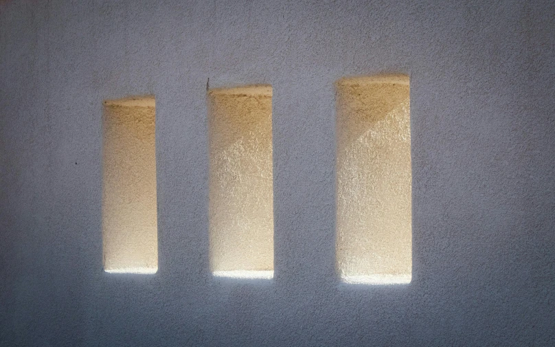 a couple of windows sitting on top of a white wall, inspired by Agnes Martin, unsplash, light and space, moonlight shafts, warm illumination, detail texture, three - point lighting