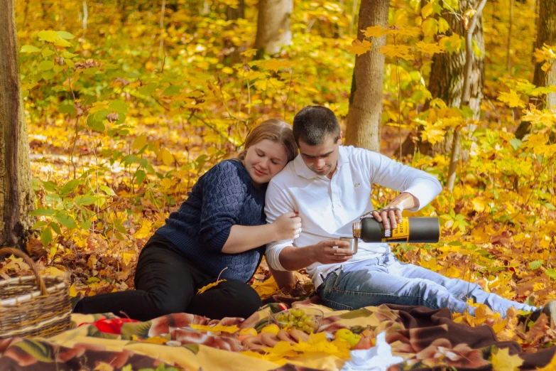 a man and a woman sitting on a blanket in the woods, by Julia Pishtar, pexels contest winner, wine, golden autumn, avatar image, maternal photography 4 k