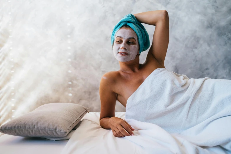 a woman with a towel wrapped around her head, by Julia Pishtar, trending on pexels, renaissance, in the bedroom at a sleepover, face mask, silver skin, teal skin