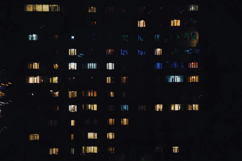 a tall building with many windows lit up at night, a screenshot, inspired by Elsa Bleda, unsplash contest winner, bauhaus, soviet apartment buildings, telephoto long distance shot, 16k resolution:0.6|people, open window at night