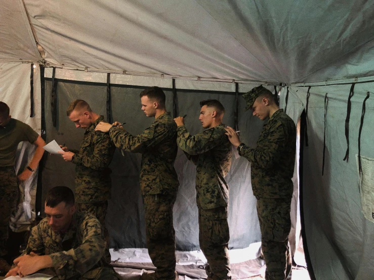 a group of men standing next to each other in a tent, marine, nerves, profile image, maintenance photo